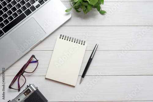 Notepad, laptop, pen on white table, Office concept.