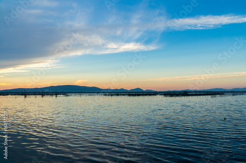 Beatiful twiligh sky over Songkhla lake with blue cloudy sky and mountain in background.