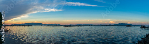 Panorama photo of beatiful twiligh sky over Songkhla lake with blue cloudy sky and mountain in background.