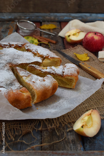 Homemade organic apple pie from yeast dough and semolina frangipan on light wooden background. Fruit dessert ready to eat. photo