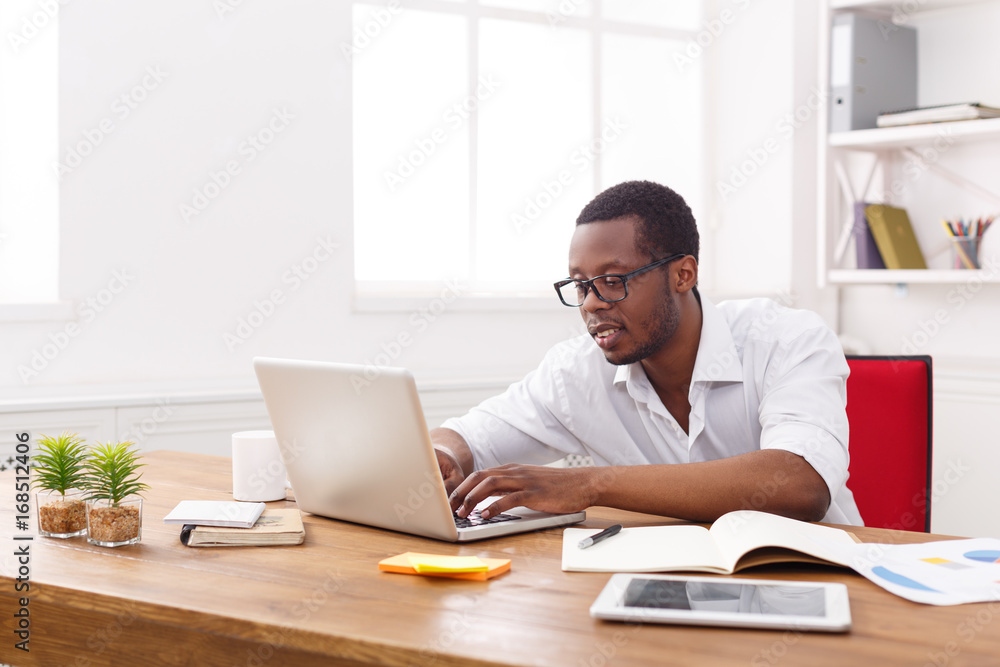 Black businessman in white office, work with laptop Black businessman in white office, work with laptop
