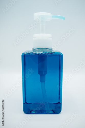 Side View. Blue dish cleansing agent in a clear bottle. Washing agent dispenser. Bubble inside the bottle.  photo