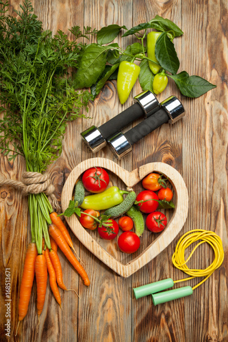 Sport and diet. Fresh vegetables. Healthy lifestyle. Rustic wooden background.