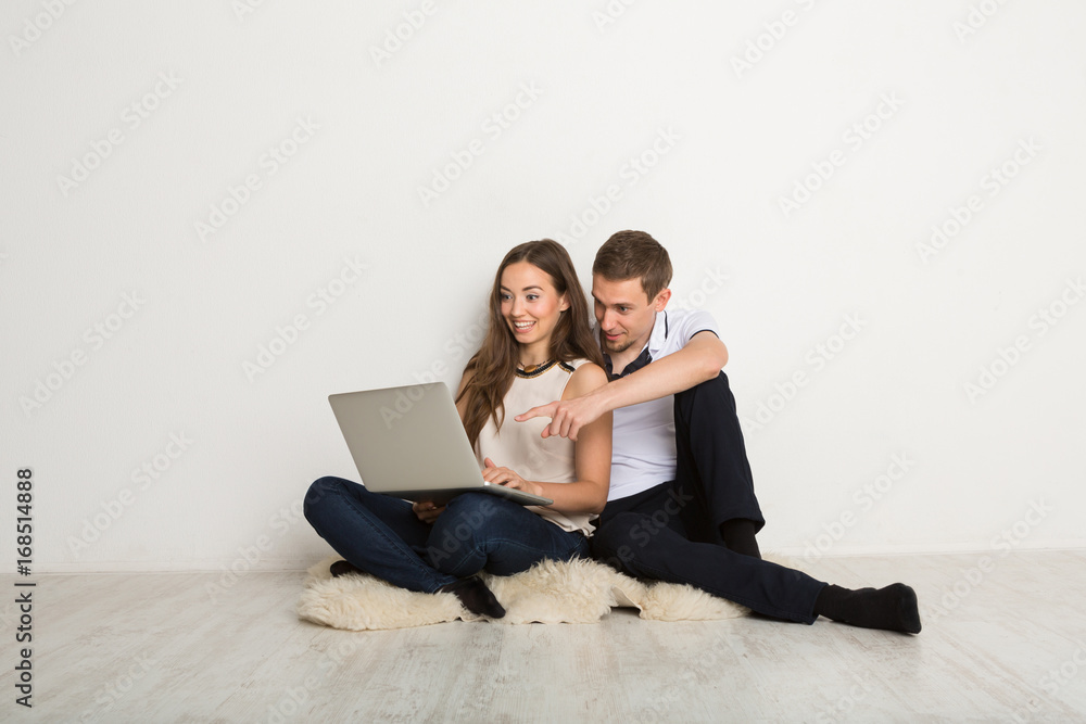 Cheerful couple using laptop at home, copy space Cheerful couple using laptop at home, copy space