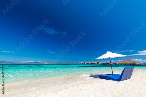Beautiful beach. Sunbeds with umbrella on the sandy beach near the sea. Summer holiday and vacation concept. Inspirational tropical beach.