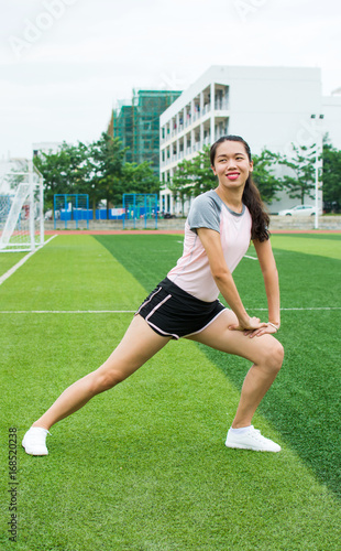 Girl stretching in the football field