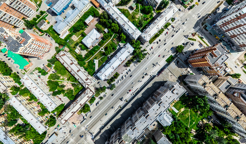 Aerial city view with crossroads and roads, houses, buildings, parks and parking lots, bridges. Helicopter drone shot. Wide Panoramic image. © mr.markin