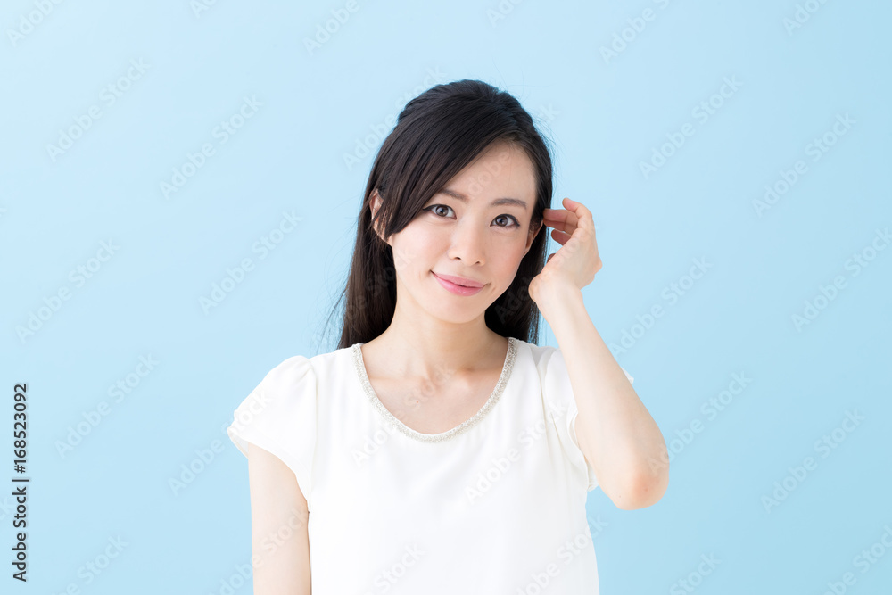 照れる女性・ブルーバック 照れる女性・ブルーバック
