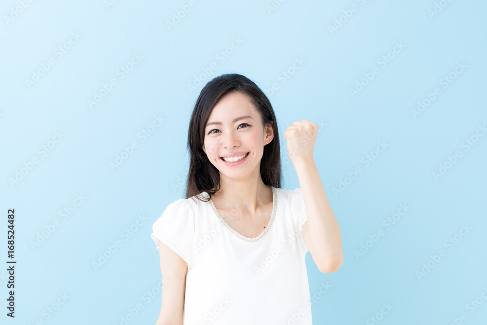 ガッツポーズ・女性・ブルーバック ガッツポーズ・女性・ブルーバック