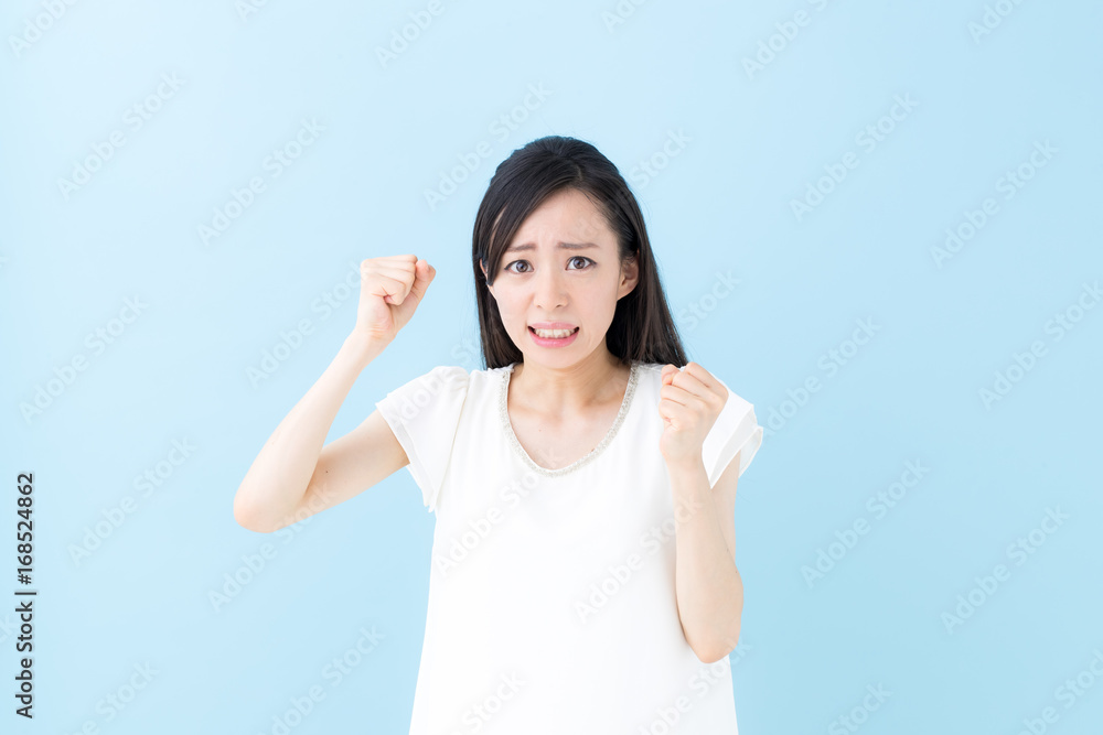 怒り・女性・ブルーバック 怒り・女性・ブルーバック