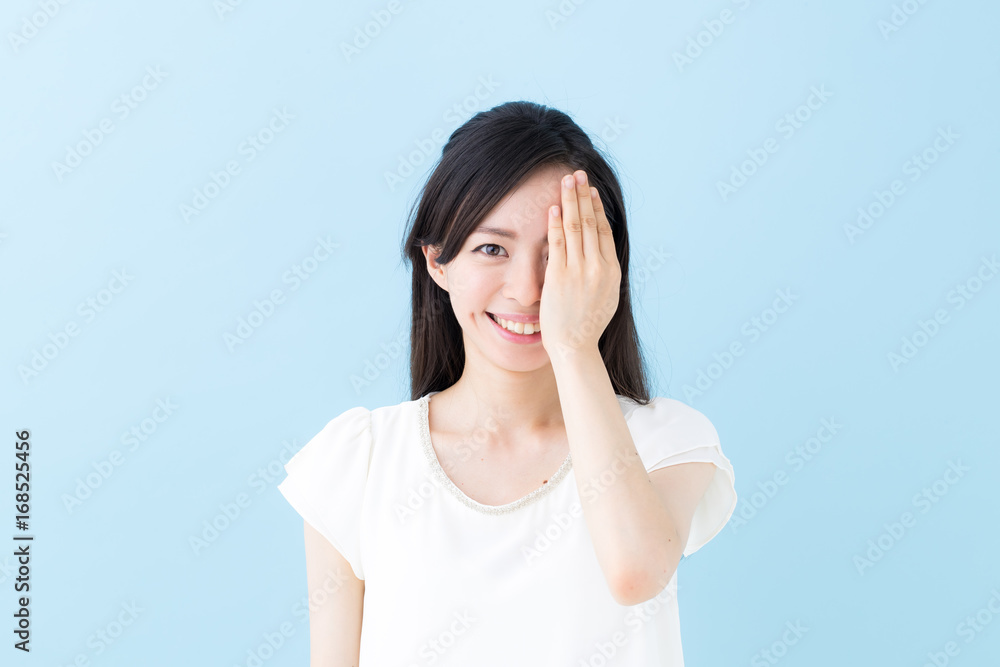 片目・女性・ブルーバック 片目・女性・ブルーバック