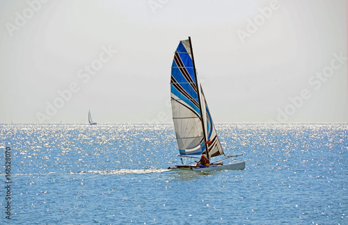 Blue sailing boat near Istanbul with shiny sea reflections