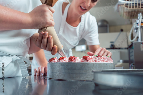 Billede på lærred Konditor benutzt Spritzbeutel für Dekoration von Torte mit Buttercreme