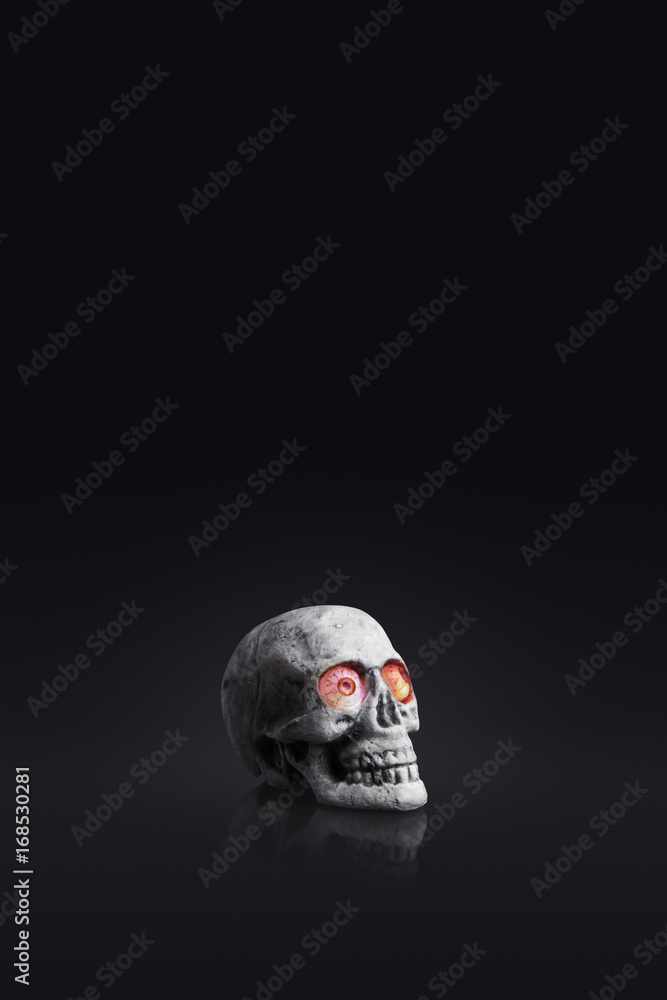 fake human skull with glowing eyes halloween concept