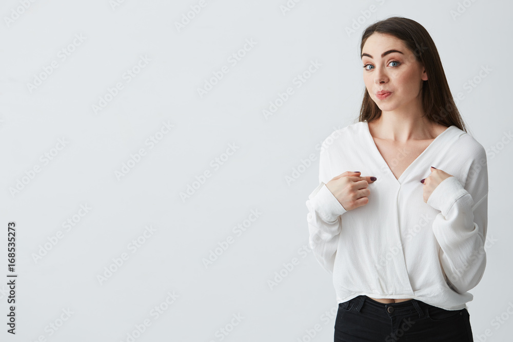 Surprised young beautiful businesswoman pointing fingers at herself looking at camera over white background. Surprised young beautiful businesswoman pointing fingers at herself looking at camera over white background.