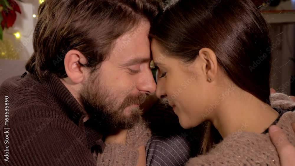 Happy in love man and woman looking into each other eyes in front of chrimstas tree closeup dolly shot Happy in love man and woman looking into each other eyes in front of chrimstas tree closeup dolly shot