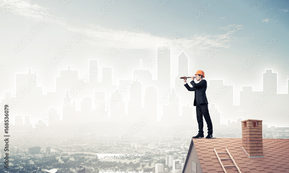 Engineer man standing on roof and looking in spyglass. Mixed med Engineer man standing on roof and looking in spyglass. Mixed med