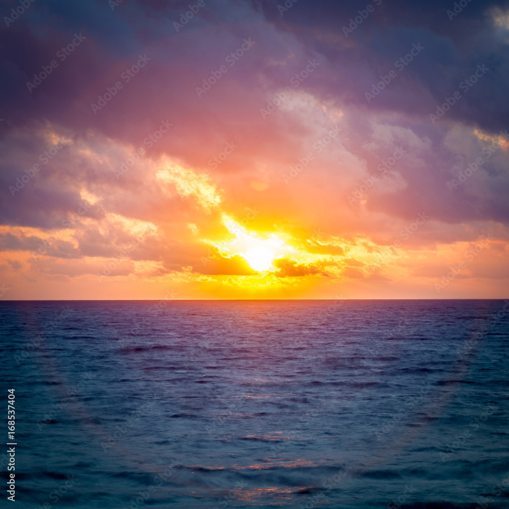 Halo effect surrounding the morning sunrise over the ocean. / Morning Sunrise Halo.
