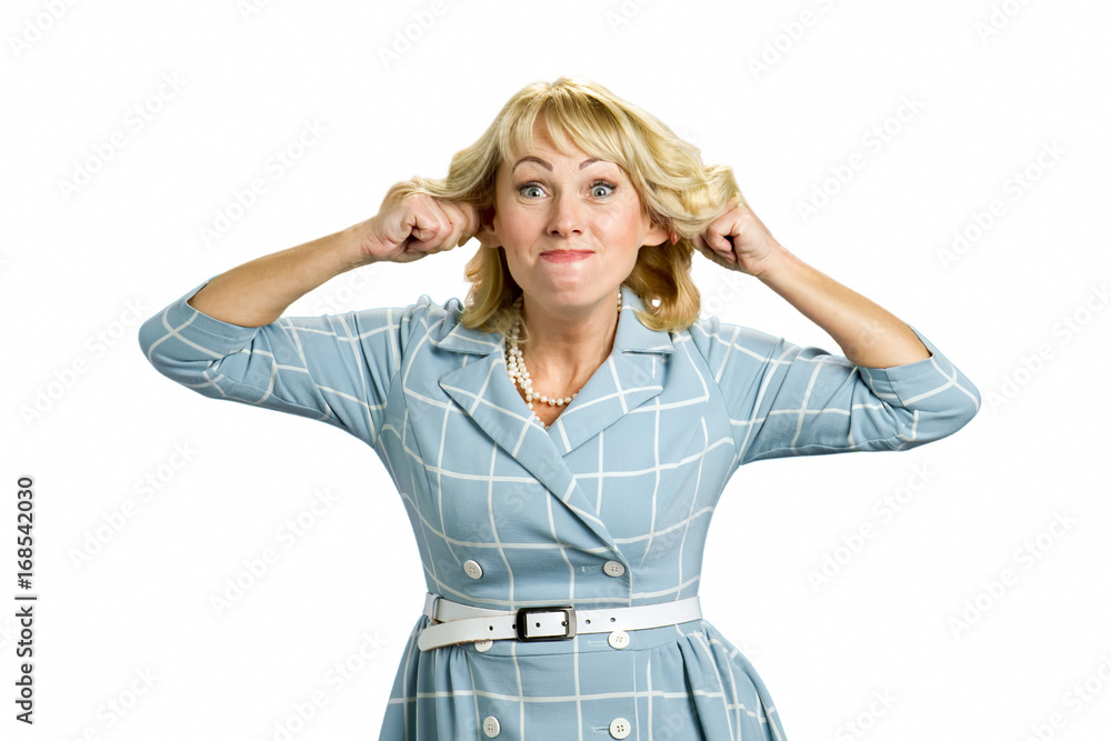 Mature woman making funny face. Middle aged woman in dress making grimace stretching ears isolated on white background. Mature woman making funny face. Middle aged woman in dress making grimace stretching ears isolated on white background.
