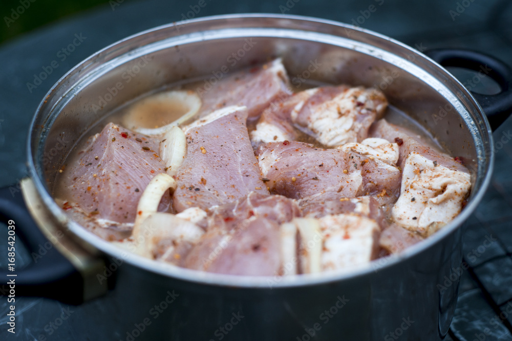 Skewers of pork meat in a saucepan