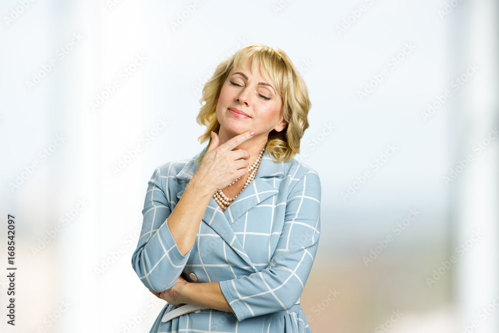 Dreaming mature woman closed eyes. Adult woman closed her eyes touching chin. Dreaming mature woman closed eyes. Adult woman closed her eyes touching chin.