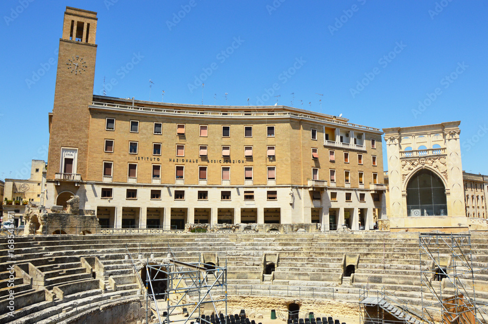 Roman amphitheater with palaces of the Sedile and the INA (Istituto Nazionale delle Assicurazioni) palace in Sant'Oronzo square in Lecce, Apulia, Italy