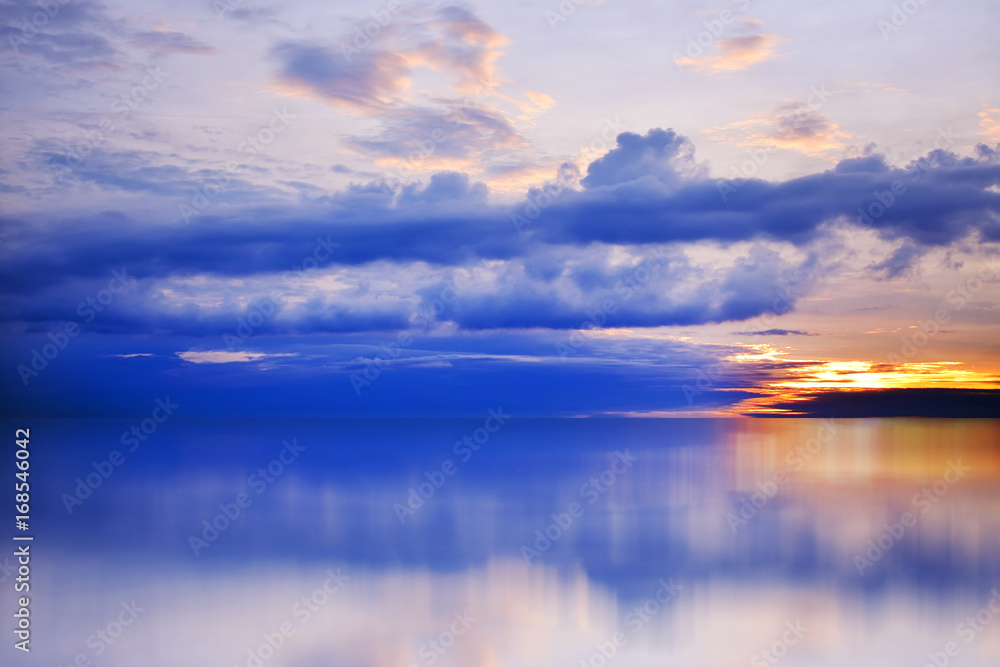 Bright, colorful sunset over the sea, blue sky, rich cloud