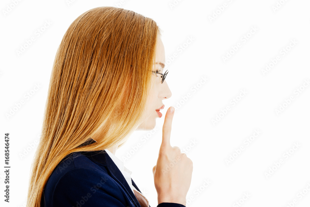 Beautiful business woman with finger on lips. Beautiful business woman with finger on lips.