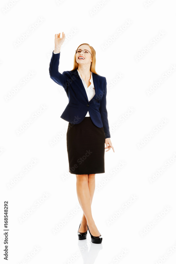 Beautiful business woman is touching an abstract space above her Beautiful business woman is touching an abstract space above her