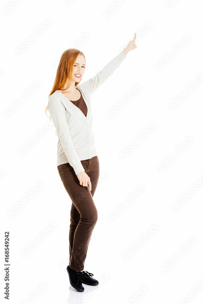Beautiful casual woman pointing up and advertising. Beautiful casual woman pointing up and advertising.