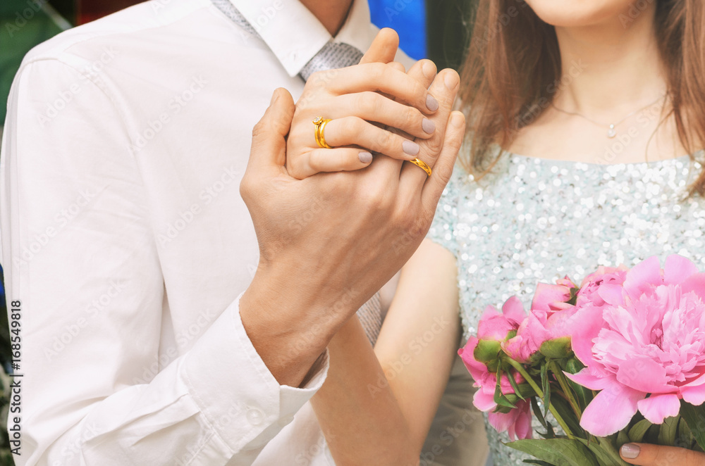 Hands of the newlyweds with wedding rings. Young family.