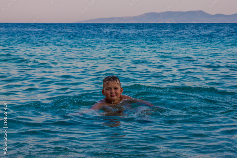 Boy dives into the clear waters of the Adriatic Sea, Croatia.