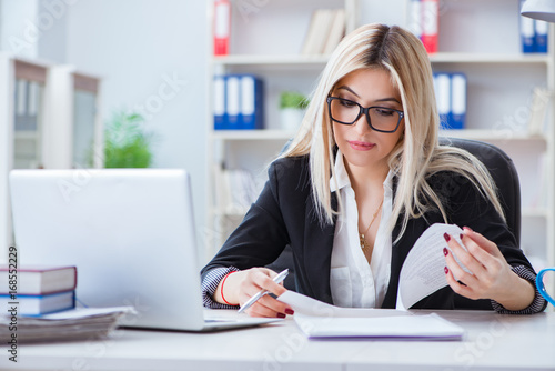 Businesswoman working on laptop at the desk in the office © Elnur