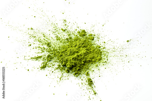 Matcha powder explosion on white background from above. Matcha is made of finely ground green tea powder. It's very common in japanese culture. Matcha is healthy due to it's high antioxydant count. photo