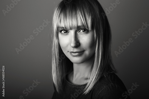 Closeup black-and-white portrait of beautiful young middle age blonde Caucasian woman looking in camera. Girl female with long blonde hair bob, studio beauty shot.