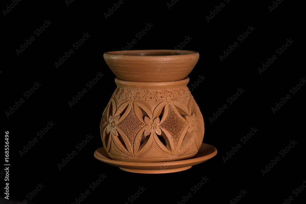 Isolated terracotta stove for aromatherapy on black background
