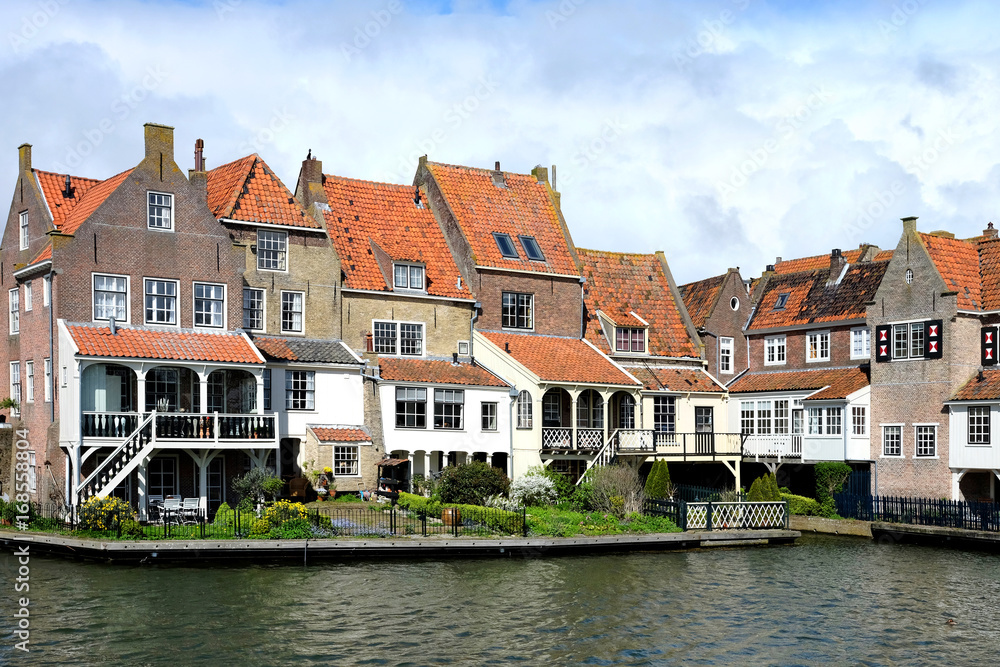View from the bridge in Enkhuizen traditional old brick buildings with tile roofs, Netherlands