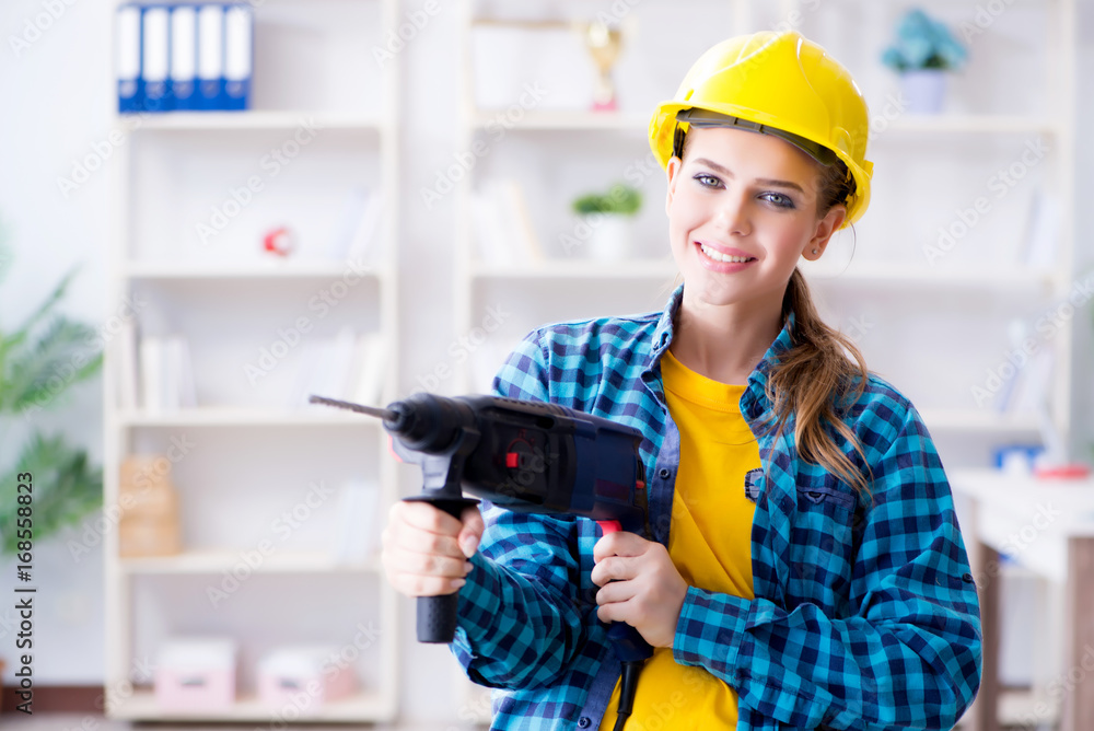 Woman in workshop with drilling drill Woman in workshop with drilling drill
