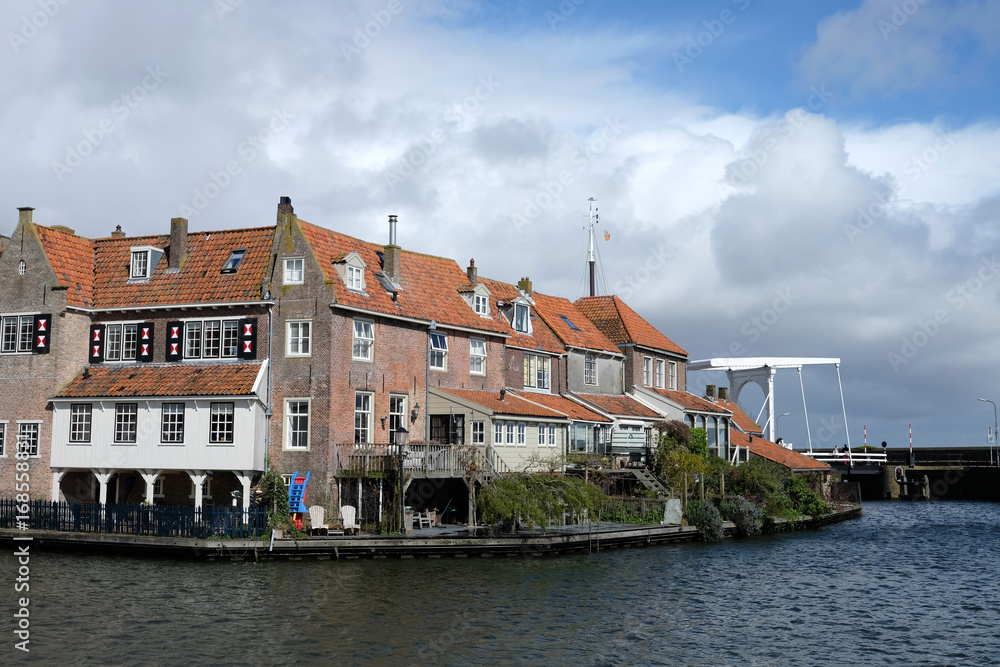 View from the bridge in Enkhuizen traditional old brick buildings with tile roofs, Netherlands