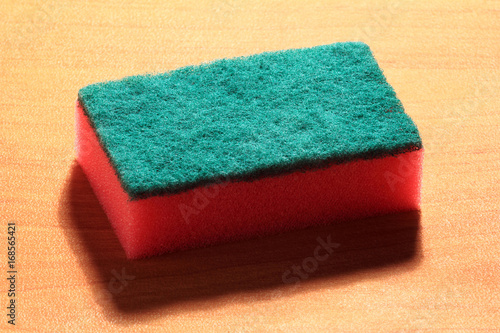 Cleaning sponge on wood background
