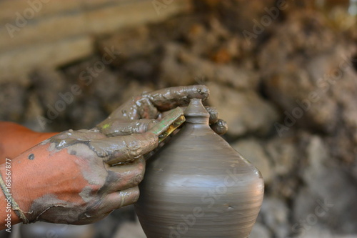 close up on hands making pots on pottery wheel