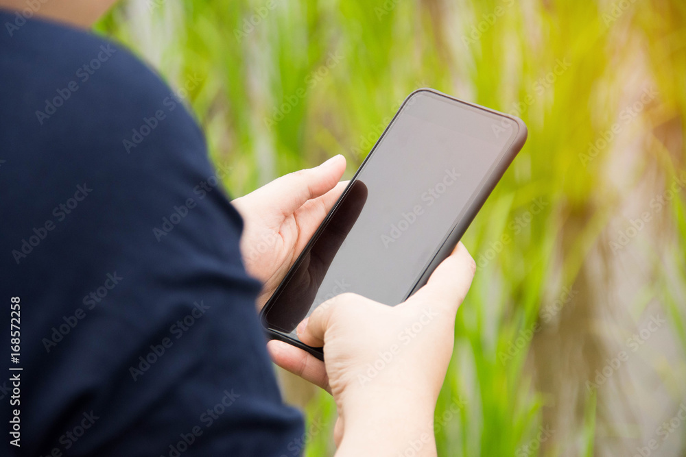 people holding smartphone with nature background.