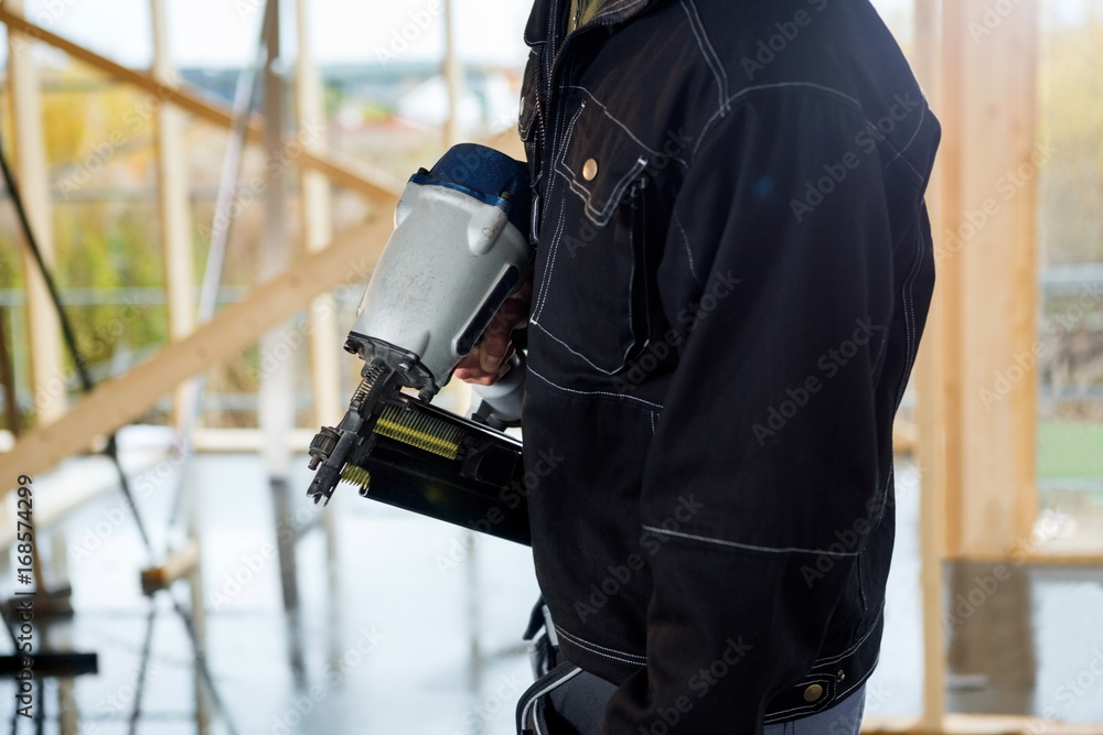 Midsection Of Carpenter Holding Drill Machine At Site Midsection Of Carpenter Holding Drill Machine At Site