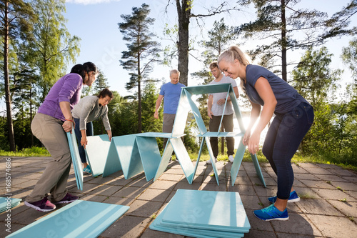 Coworkers Making Pyramid With Blue Planks On Patio photo
