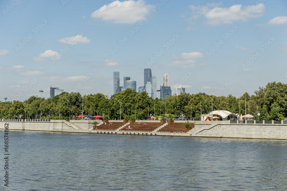 Fototapeta premium View of riverside of Moscow river and Moscow city skyscrapers behind the trees