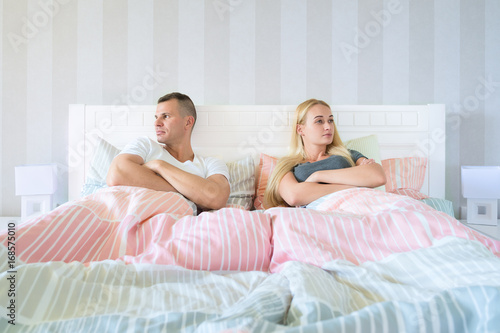 Slika na platnu Upset young couple having marital problems or a disagreement sitting side by sid