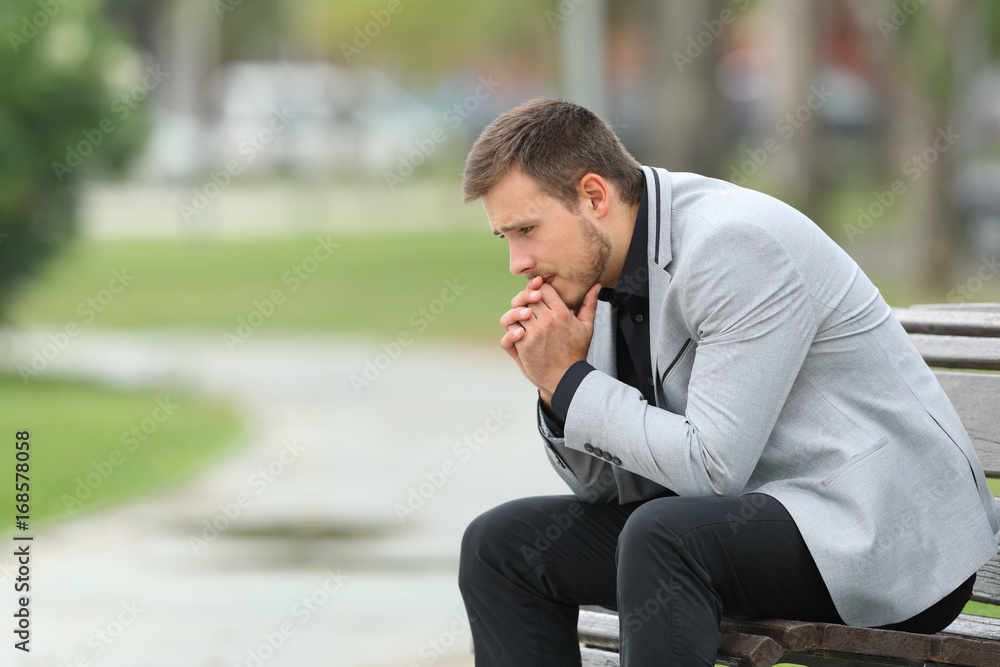 Worried businessman sitting on a bench Worried businessman sitting on a bench