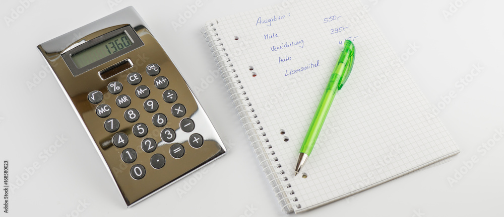 Ein Schreibblock mit einer Berechnung der Ausgaben, ein grüner Stift und Taschenrechner, Banner, Panorama, Ein Schreibblock mit einer Berechnung der Ausgaben, ein grüner Stift und Taschenrechner, Banner, Panorama,