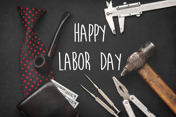 happy labor day text sign concept flat lay. working tools, bow tie leather wallet with money wooden tobacco pipe and razor on black background with space for text, top view. greeting card