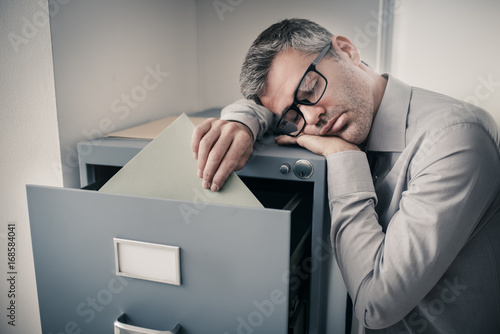 Tired office worker sleeping in the office photo